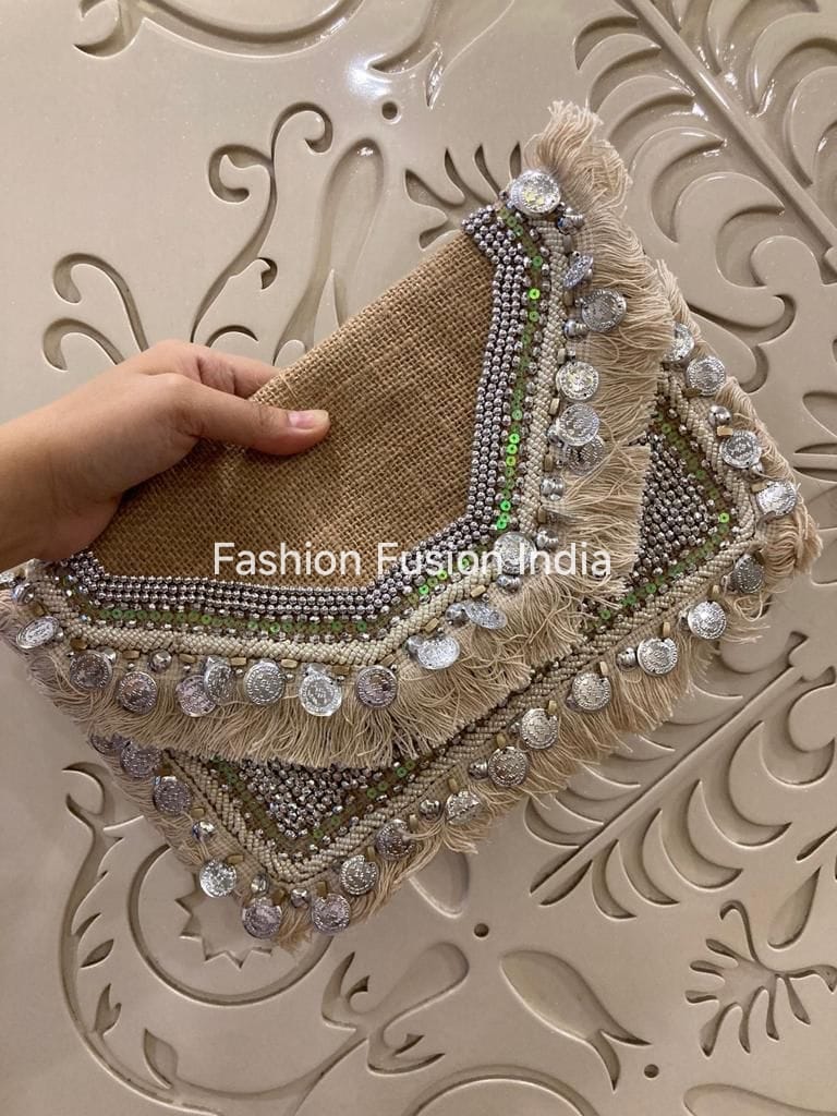 Decorative headpiece with beads and embroidery held by a hand against an ornate wall.