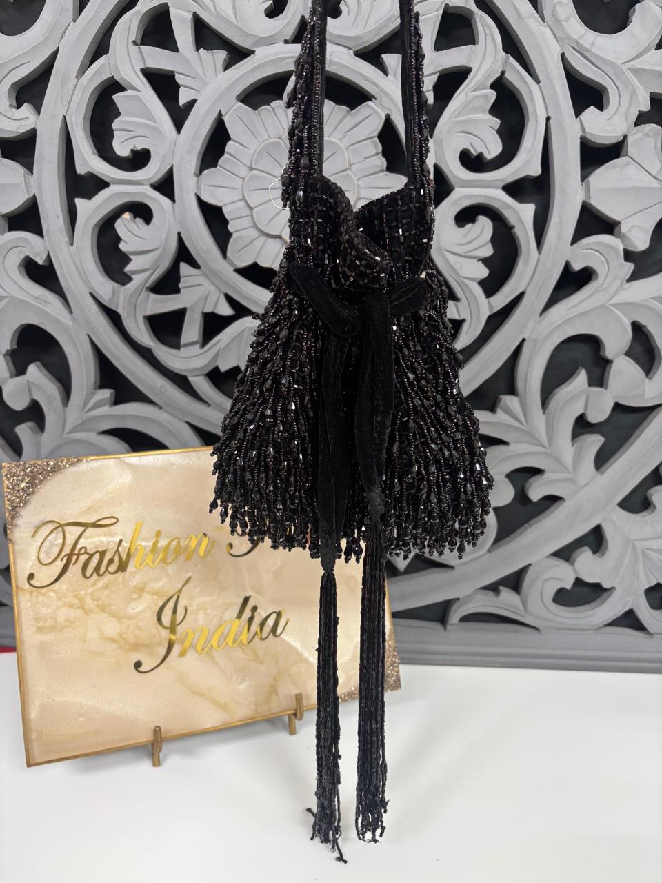 Black beaded necklace with tassels on a decorative background