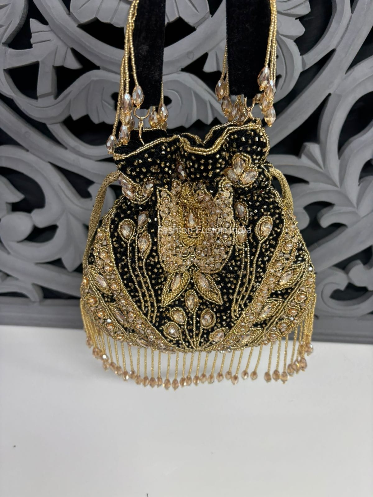 Decorative handbag with gold embroidery and beads on a white background