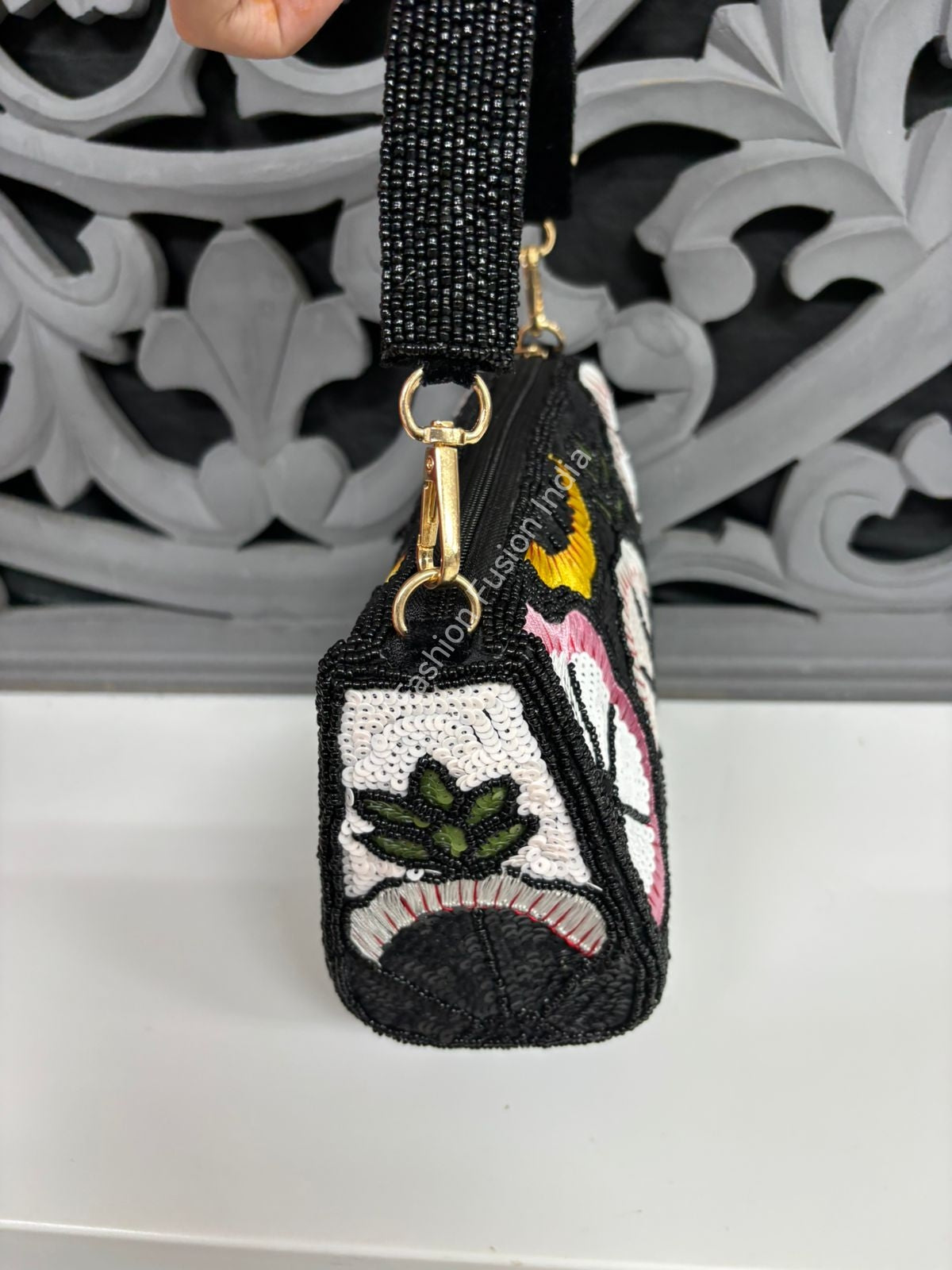 Black beaded keychain with colorful designs on a decorative background