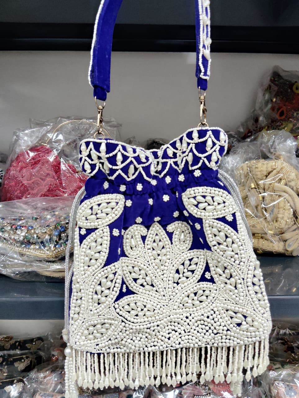 Blue and white beaded handbag with fringe on a blurred background