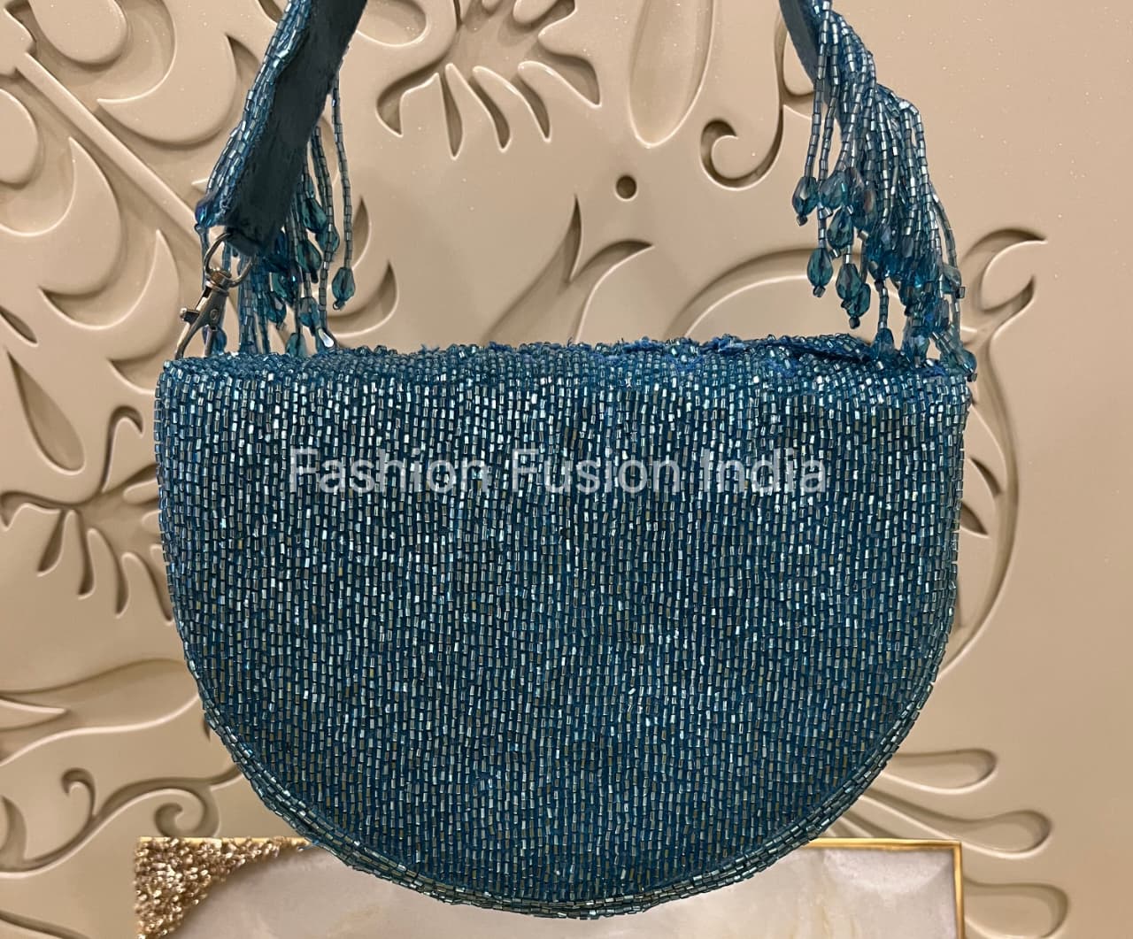 Blue beaded handbag with tassels on a decorative background