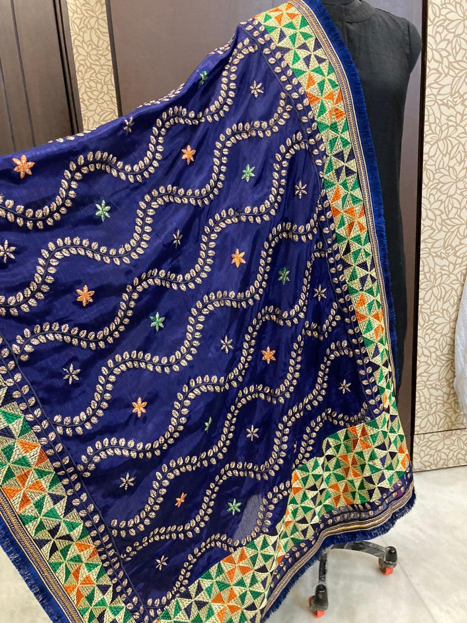 Blue embroidered fabric with colorful patterns on a chair