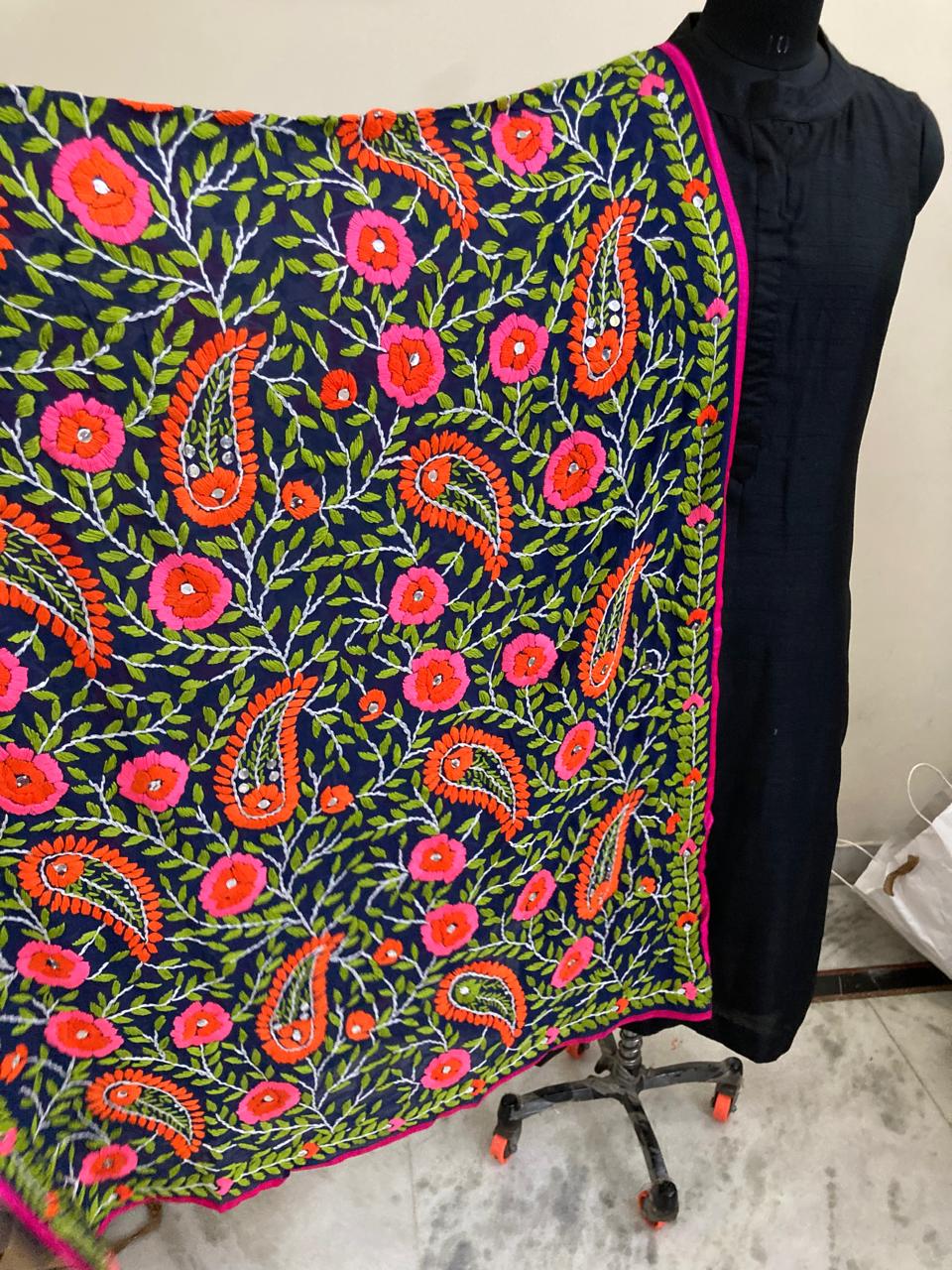 Colorful floral and paisley patterned fabric draped over a mannequin against a neutral background