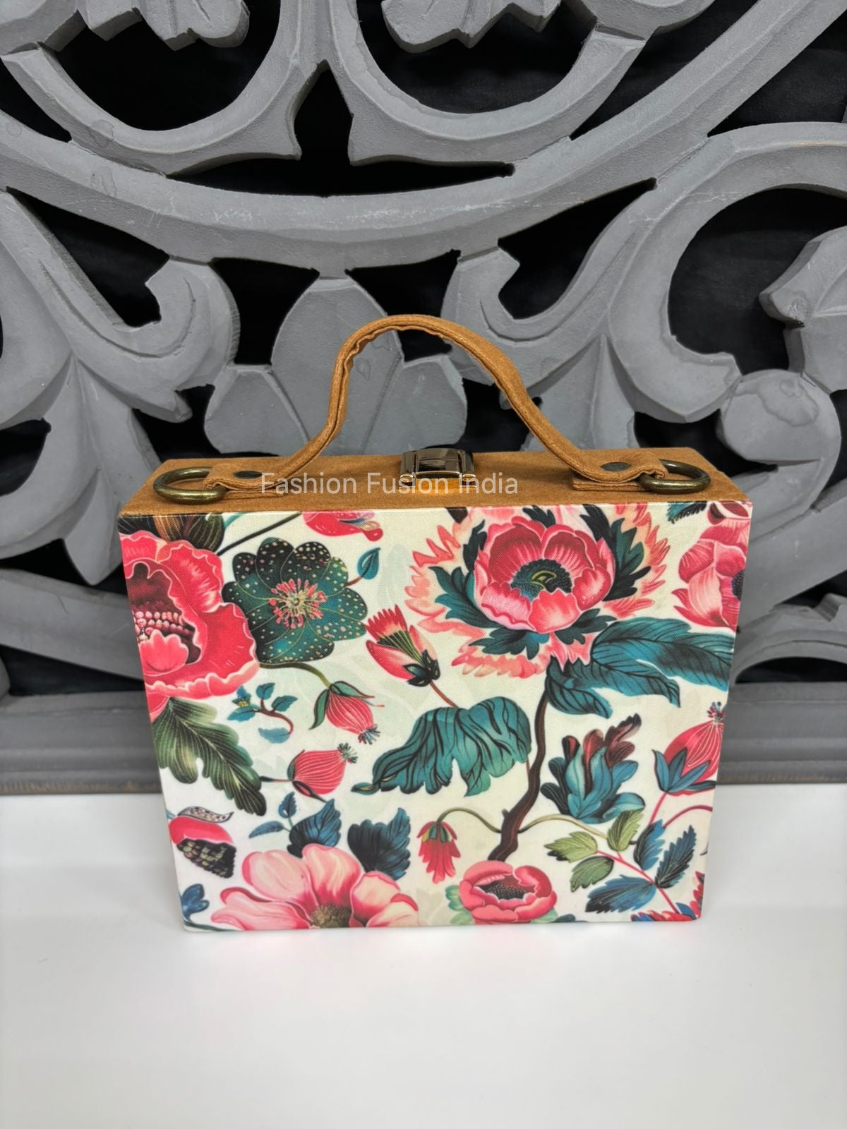 Vintage botanical wooden clutch bag against carved grey backdrop.