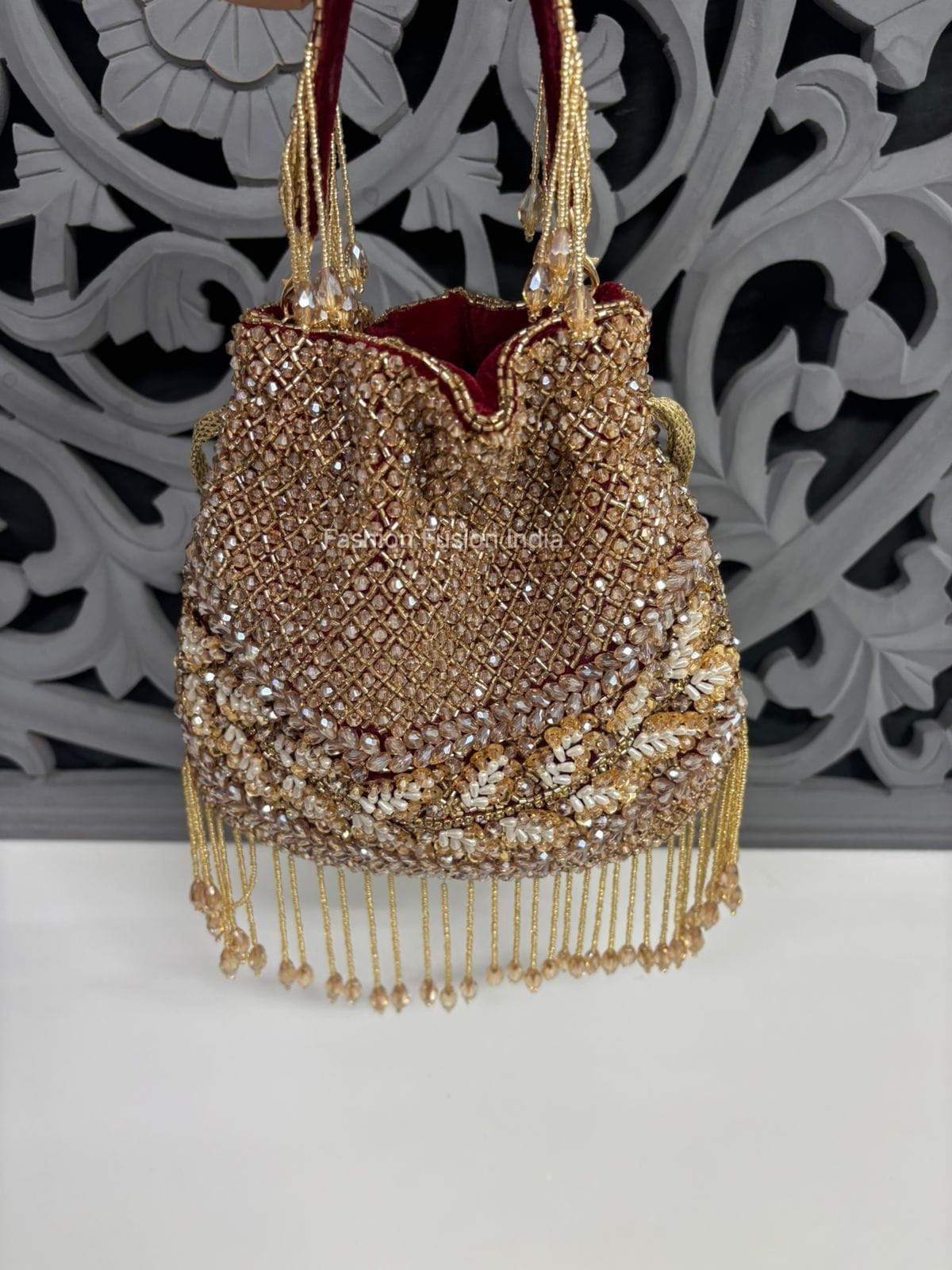 Decorative handbag with gold beads and tassels on a white background