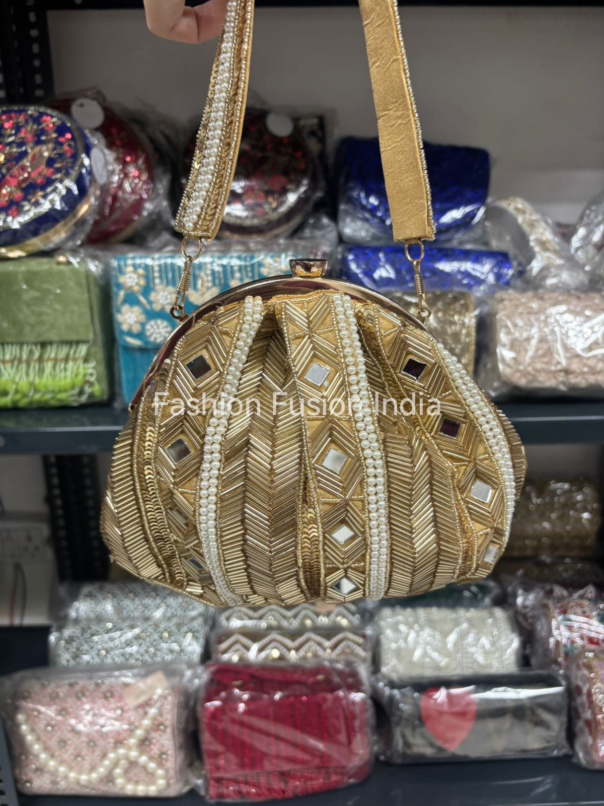 Gold embroidered handbag with a blurred background of various bags