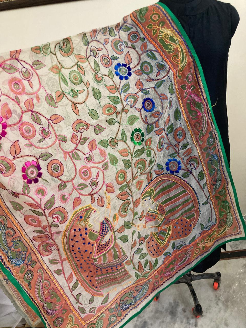 Colorful embroidered fabric with intricate patterns on a black chair.