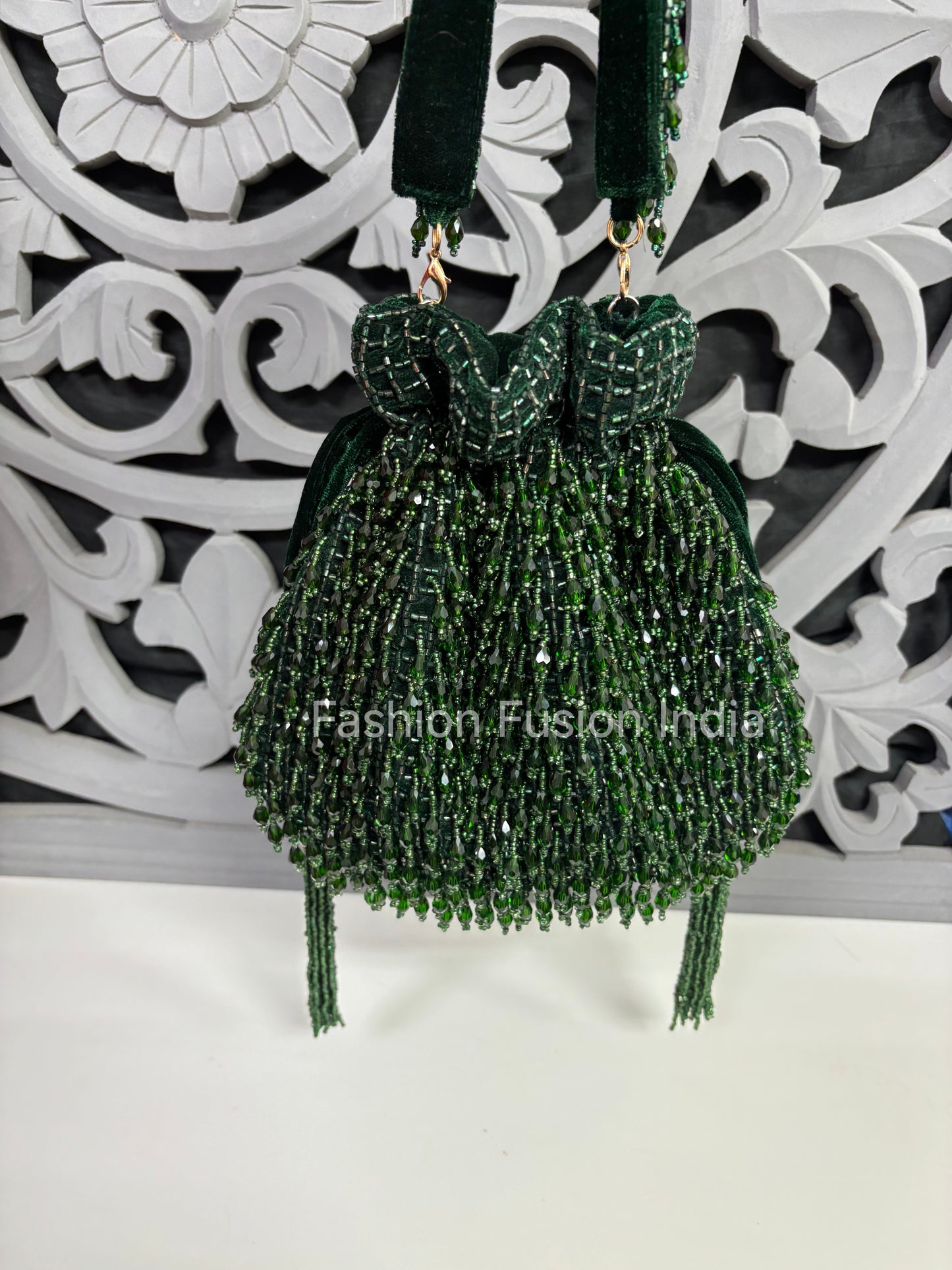 Green beaded earrings on a decorative white background