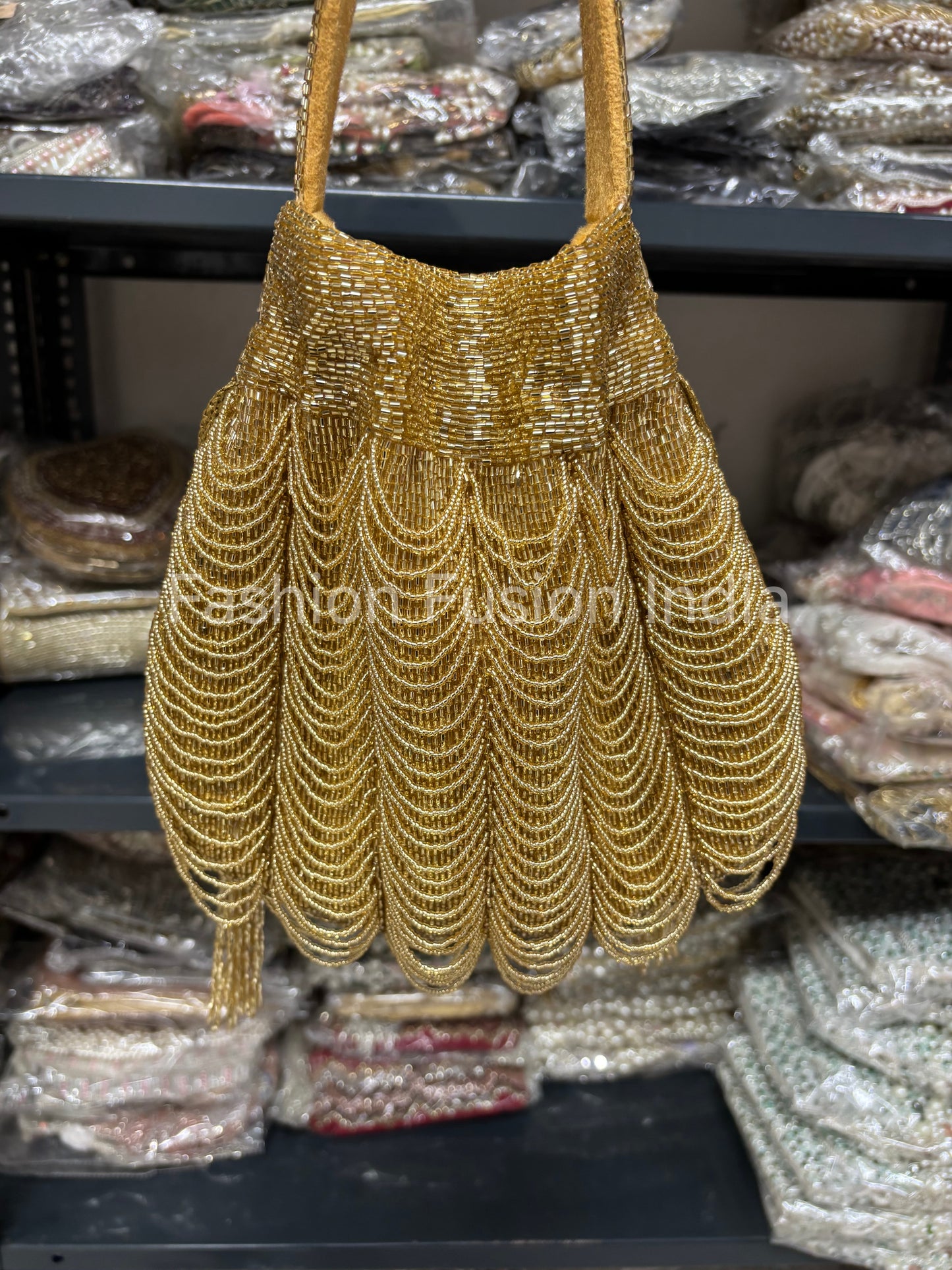 Gold beaded handbag on a shelf with other bags in the background