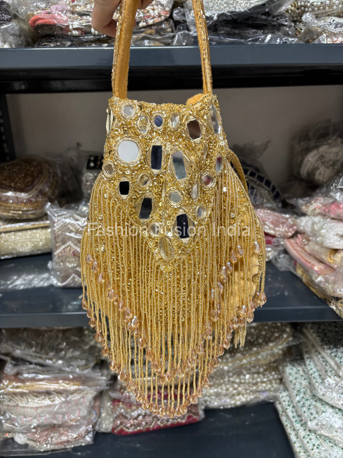 Gold beaded handbag with mirror details on a blurred background
