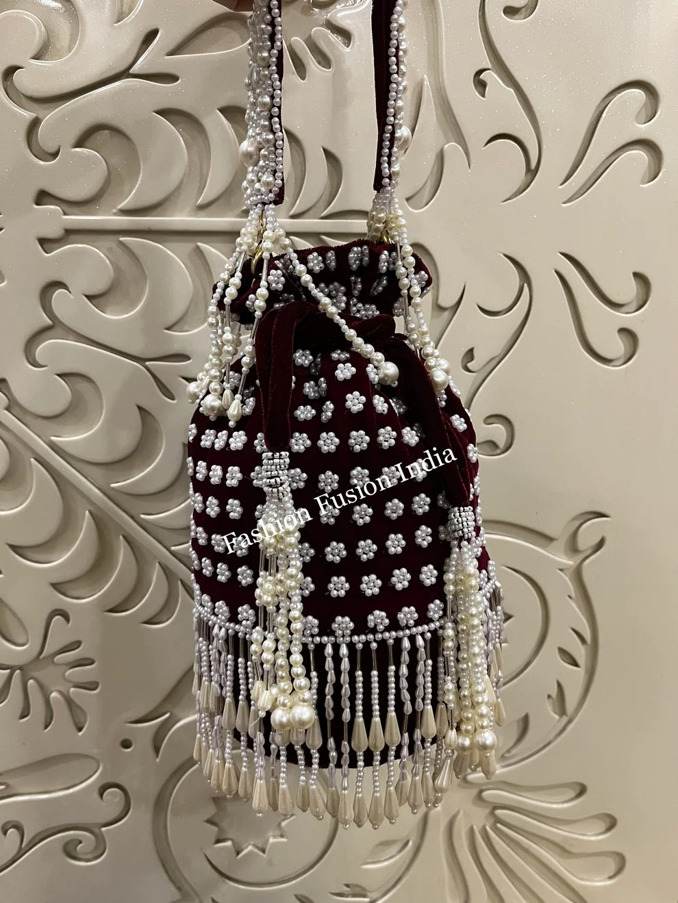Decorative handbag with pearls and crystals on a textured wall background