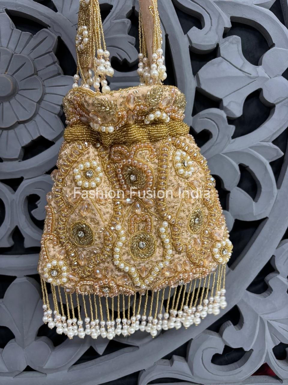 Gold beaded handbag with pearls on a decorative background