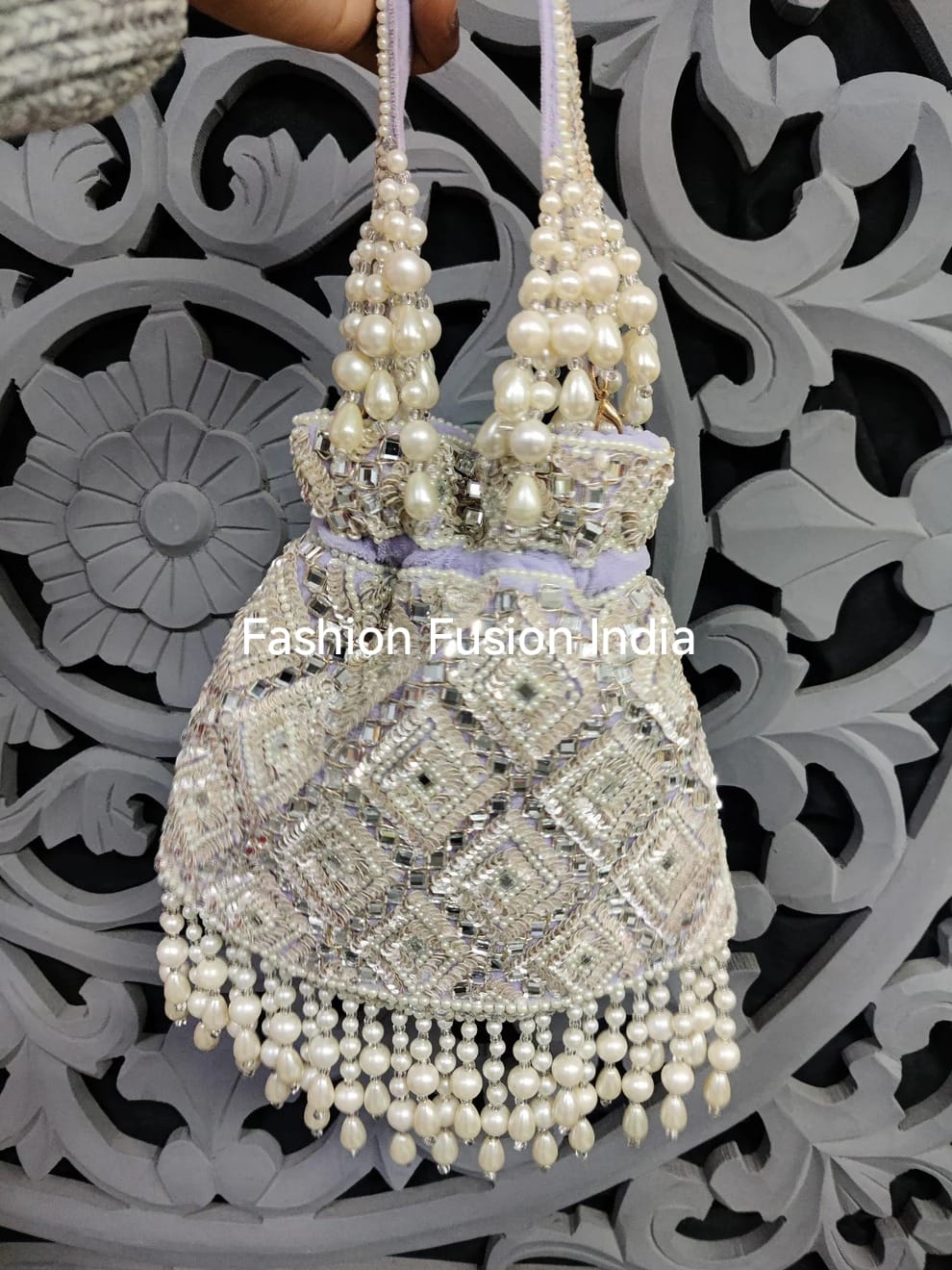 Decorative handbag with pearls against a decorative black and white background
