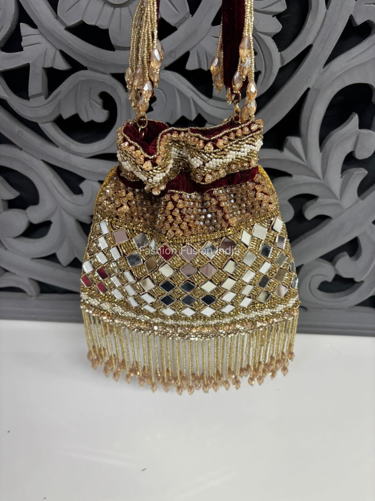 Decorative handbag with intricate designs and beads on a white background