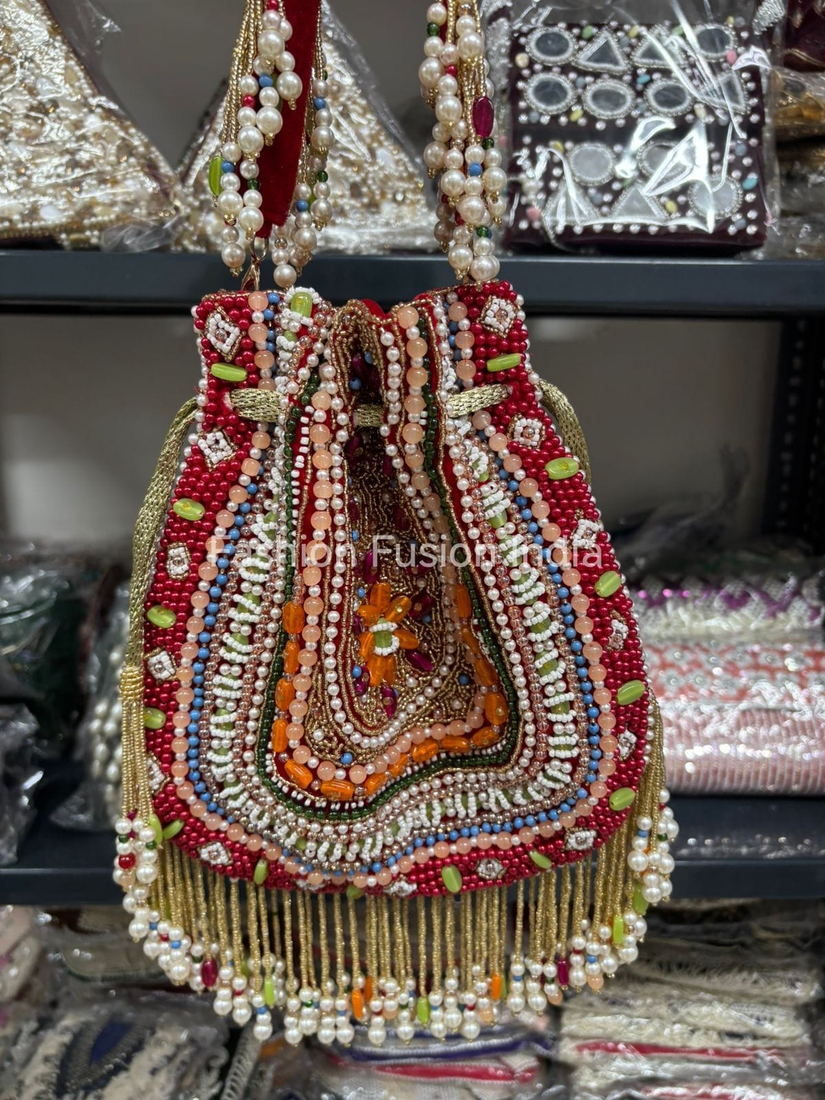 Decorative handbag with beads and embroidery on a shelf.