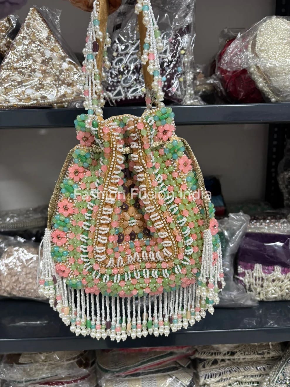 Decorative beaded handbag with floral patterns on a shelf with similar items.