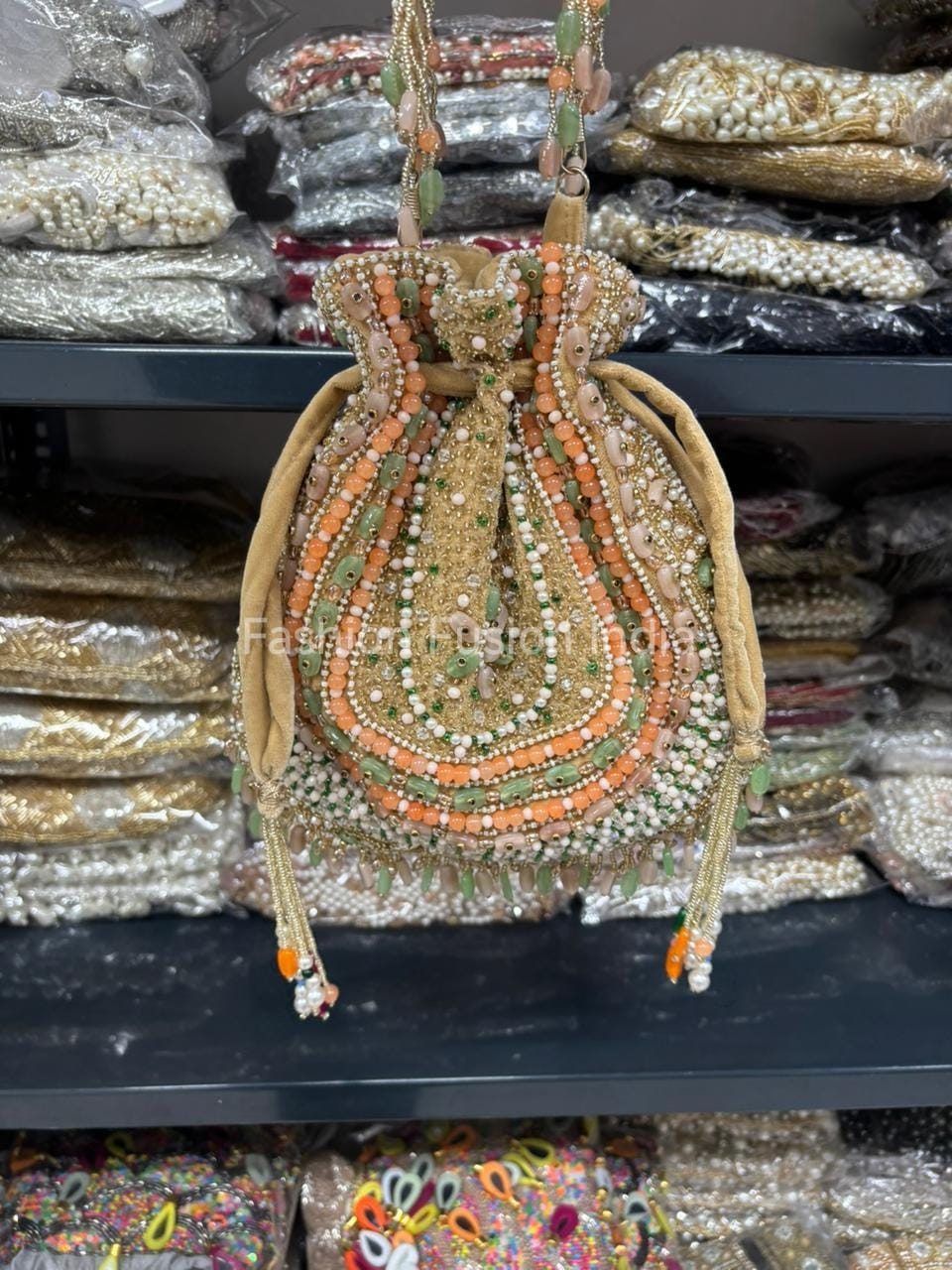 Decorative handbag with beads and embroidery on a shelf with similar bags.