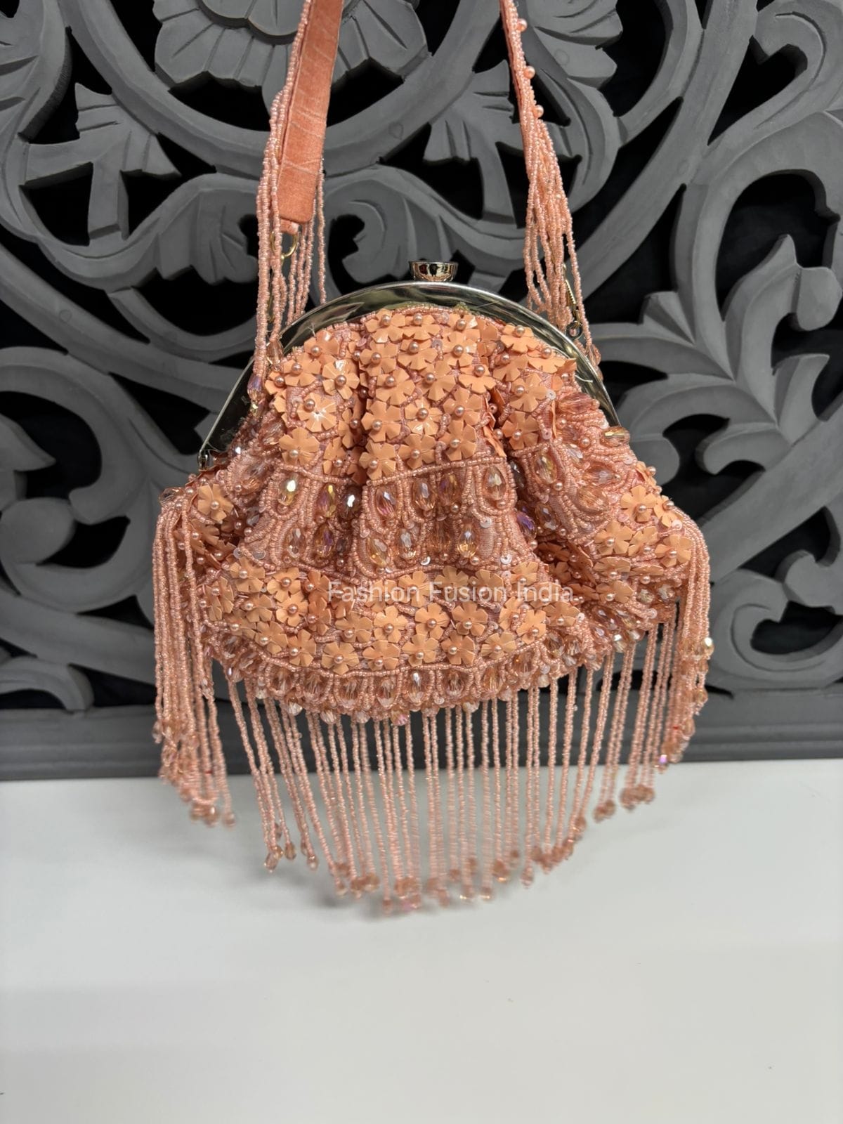 Beaded handbag with fringe details on a decorative background