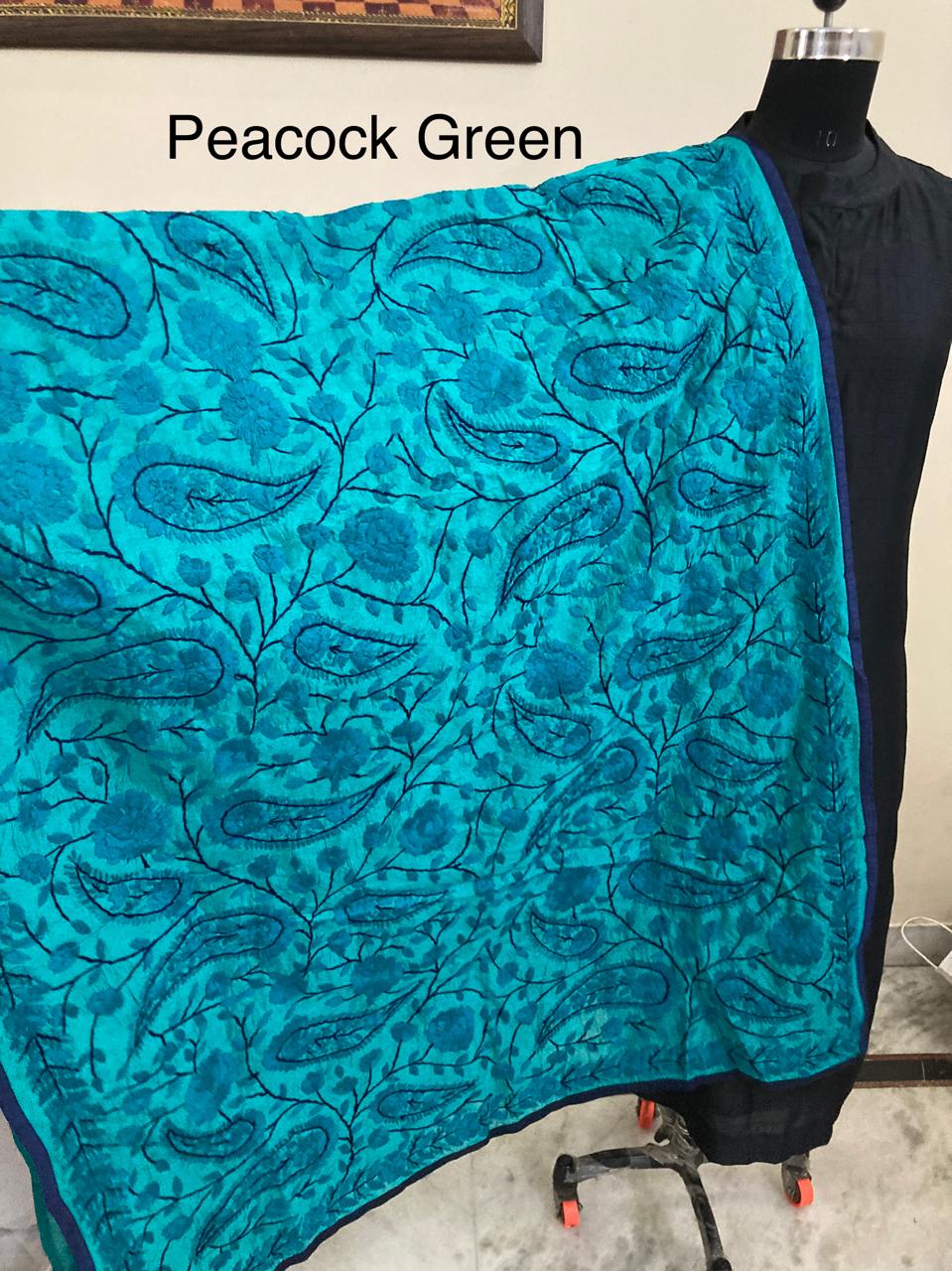 Turquoise fabric with paisley patterns draped over a mannequin against a neutral background.