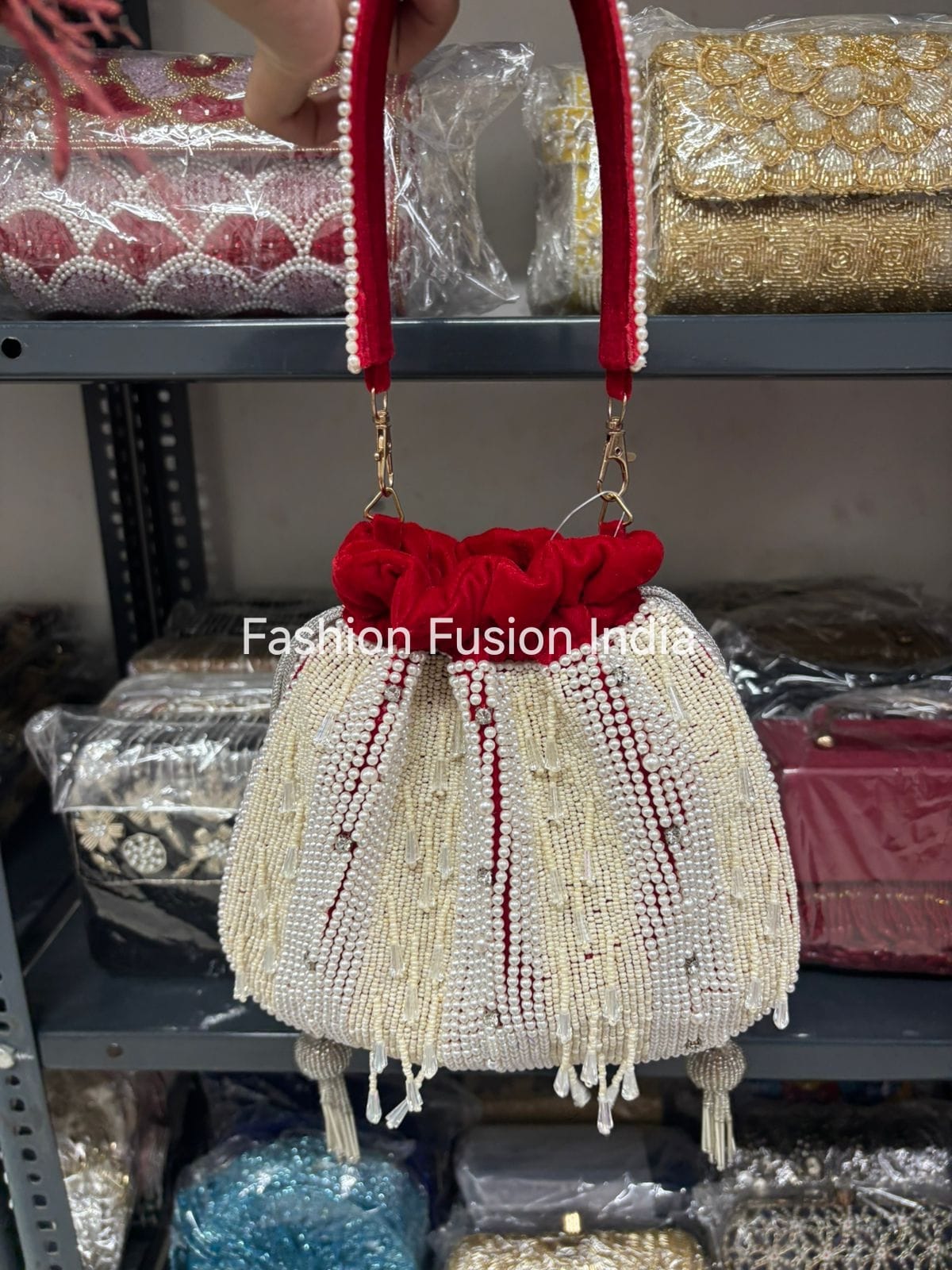 Decorative handbag with red bow and beaded details on a blurred background