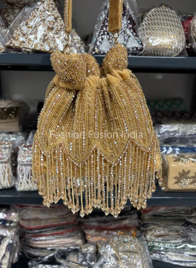 Gold beaded handbag with tassels on a blurred background