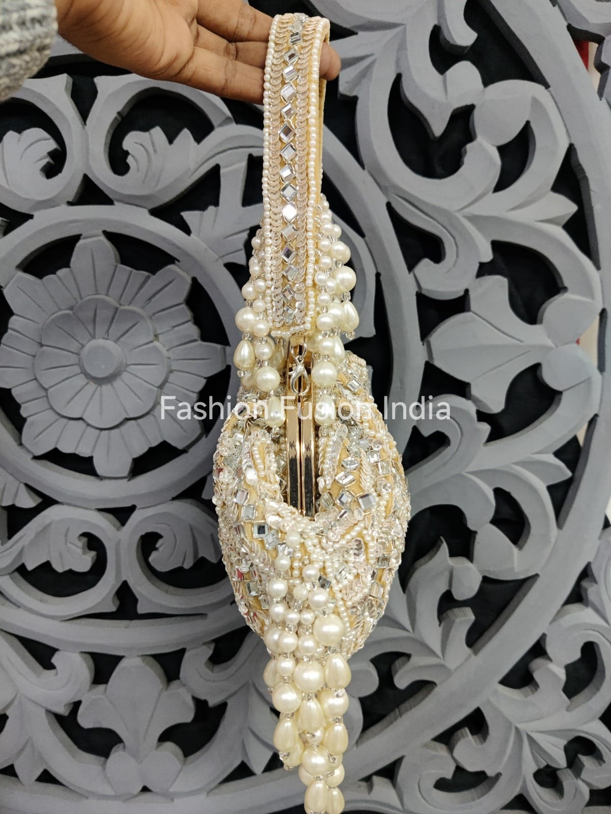 Decorative handbag with pearls and crystals against a decorative background