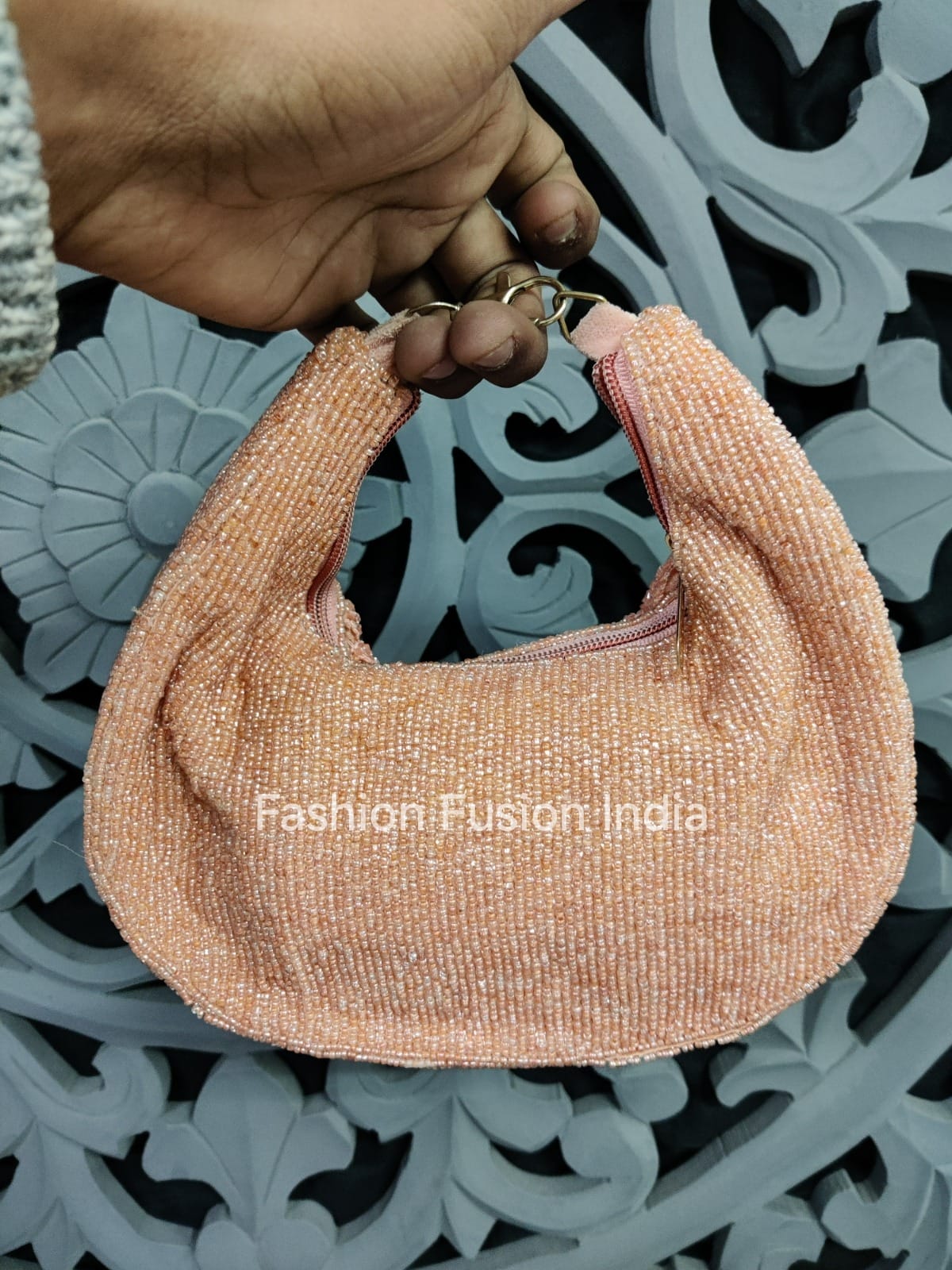 Hand holding a glittery pink handbag against a decorative metal background with 'Fashion Fusion India' branding.