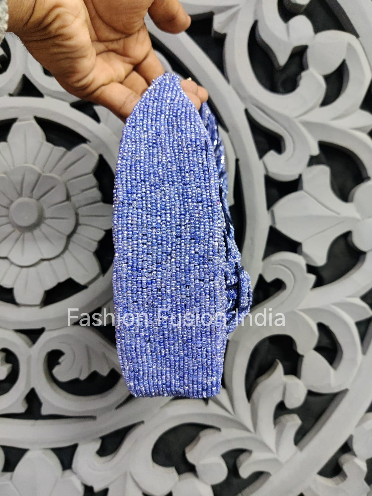Blue beaded bracelet held by a hand against a decorative white background with 'Fashion Fusion India' branding.