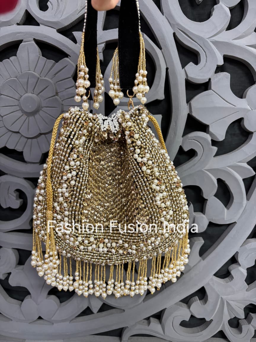 Decorative handbag with pearl details against a decorative wall.