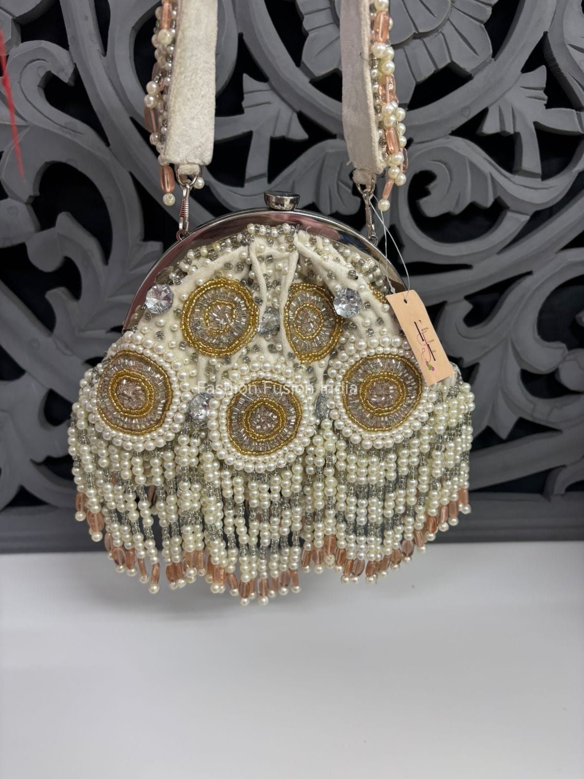 Decorative handbag with beaded and embroidered design on a neutral background