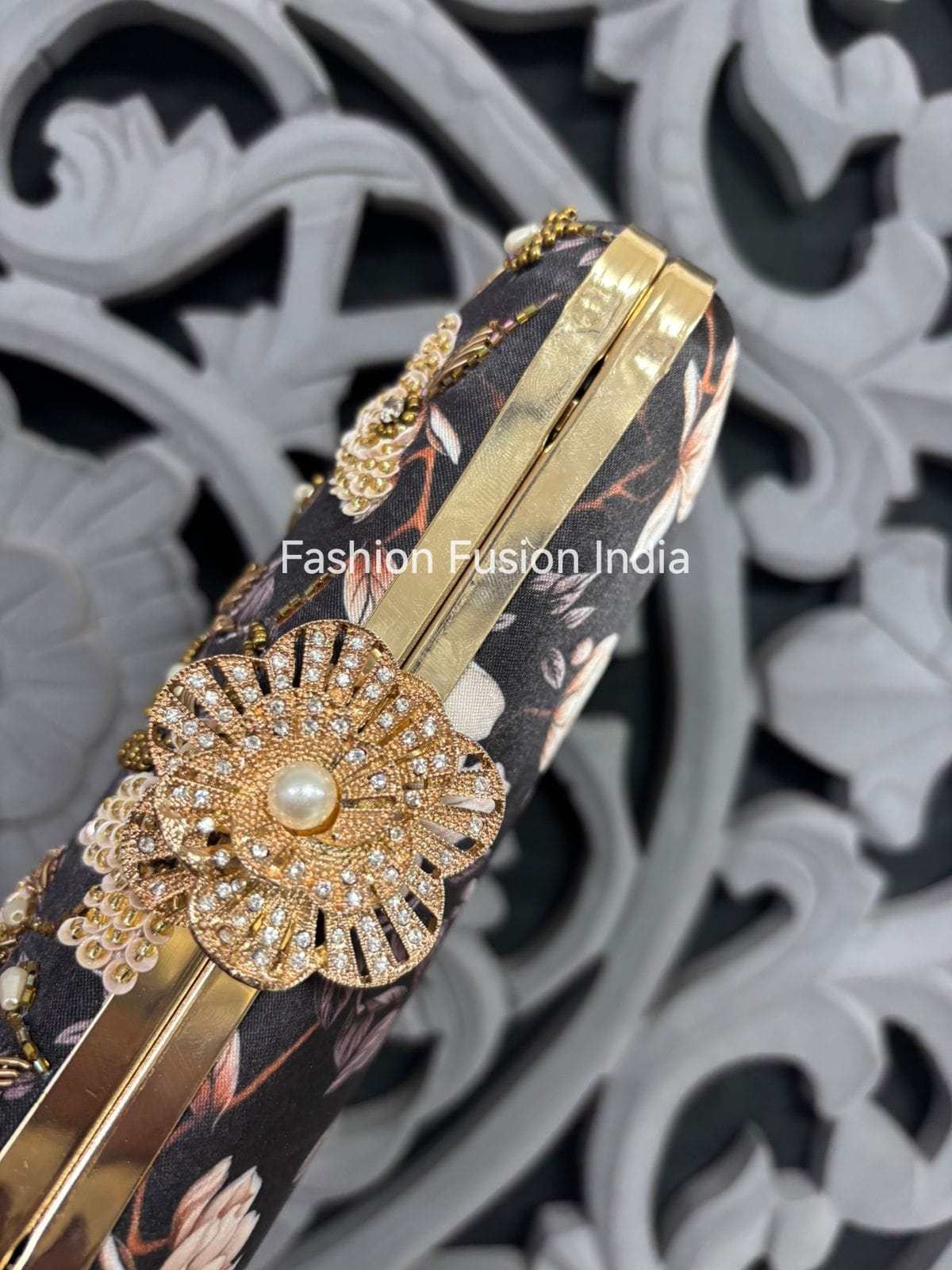 Decorative phone case with floral design and gold embellishments on a black background.