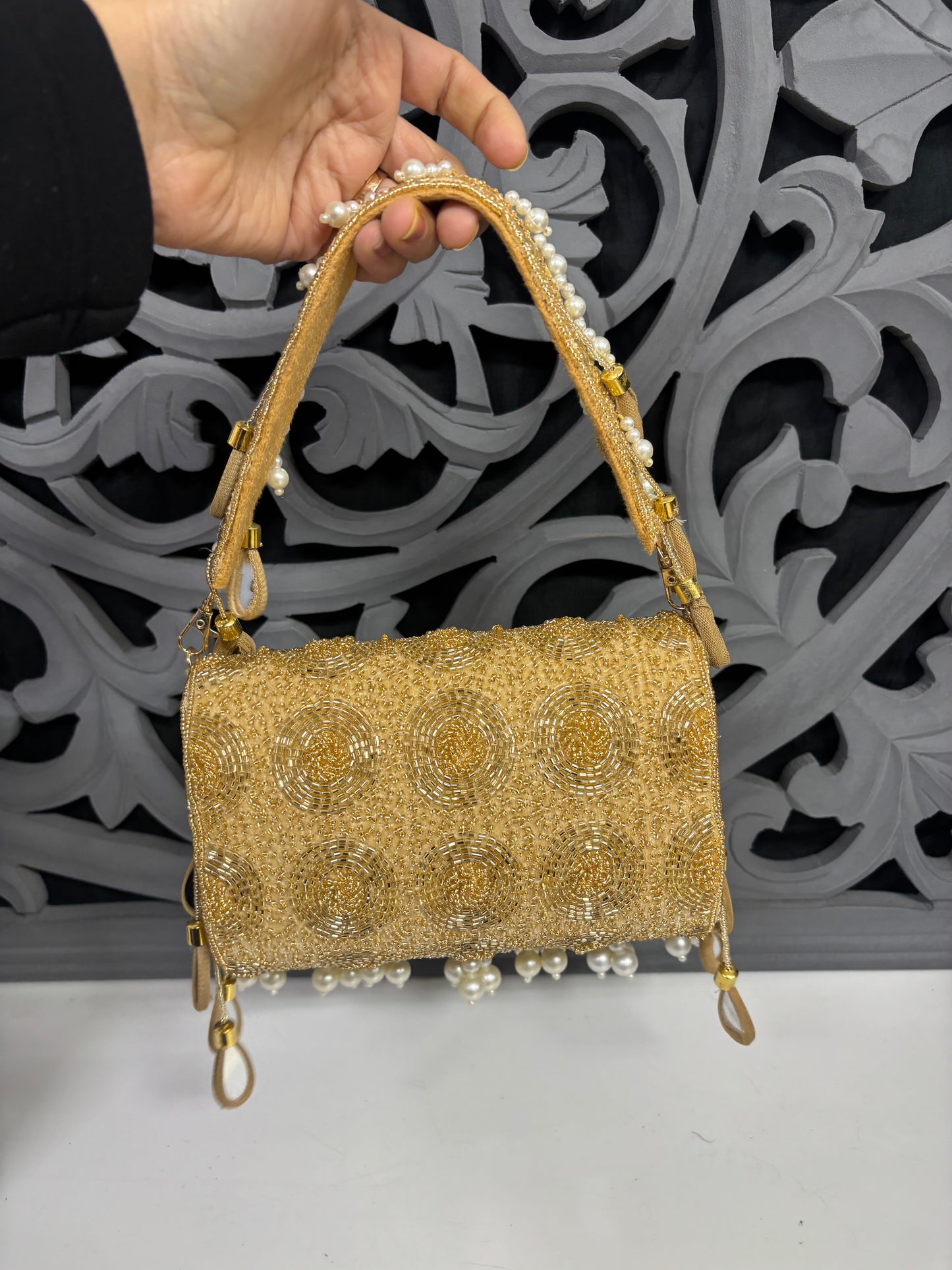 Back view of gold beaded embroidered flap clutch bag with circular handwork pattern and pearl handle, luxury ethnic clutch