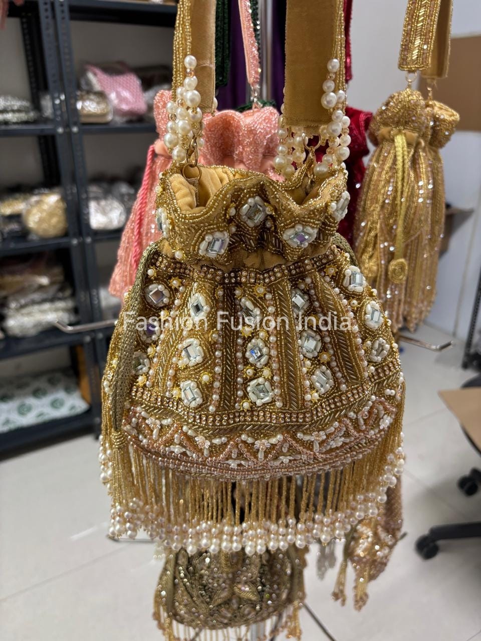 Decorative handbag with pearls and beads on a white floor.