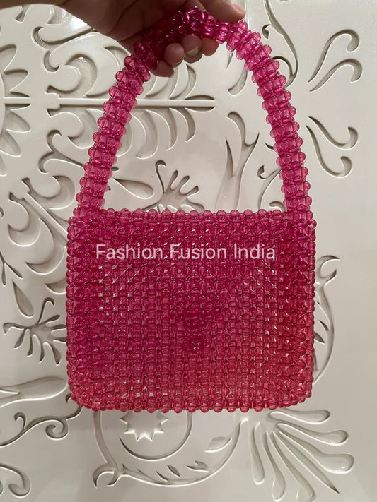 Pink beaded handbag held by a hand against a decorative white background with 'Fashion Fusion India' branding.