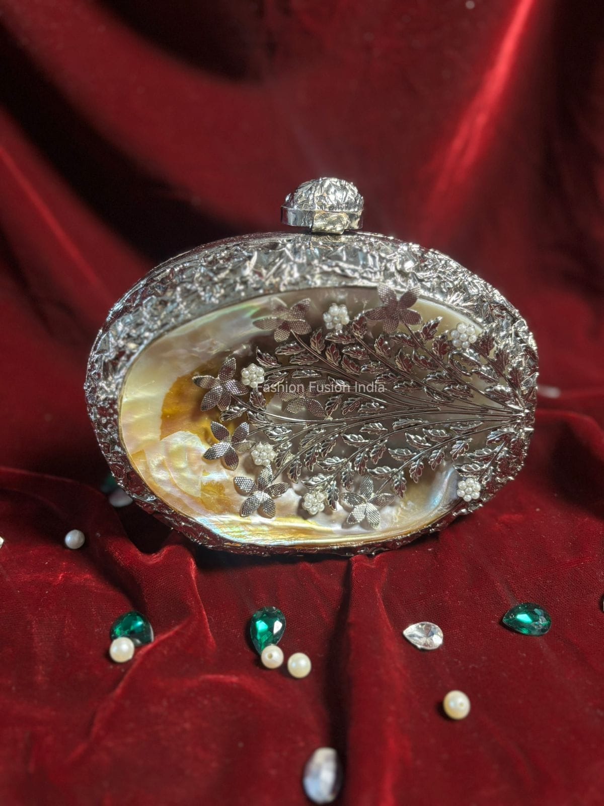 Decorative clutch with intricate design on a red fabric background