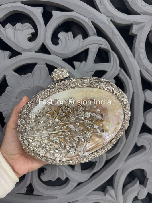 Decorative clutch held by a hand with intricate background
