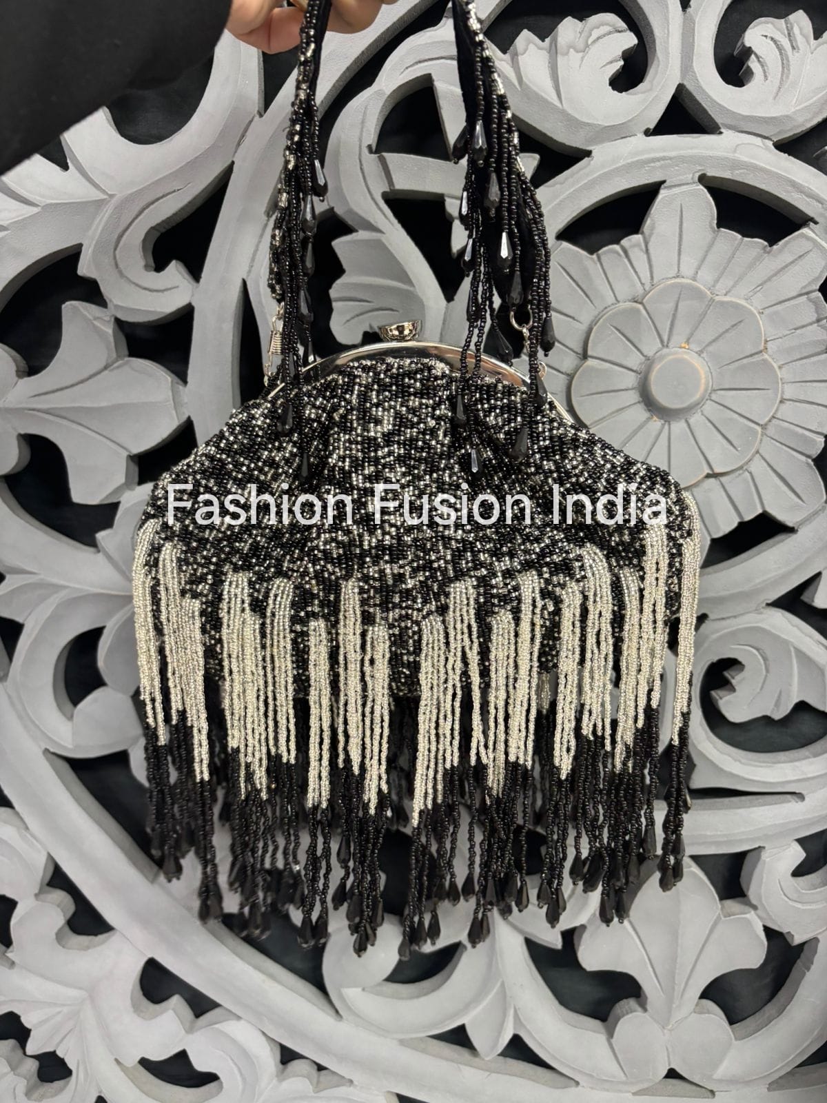 Black beaded handbag with tassels held against a decorative white background, branded 'Fashion Fusion India'.