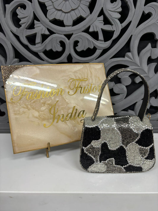 Black and white patterned handbag in front of a 'Fashion Fusion India' branded stand.
