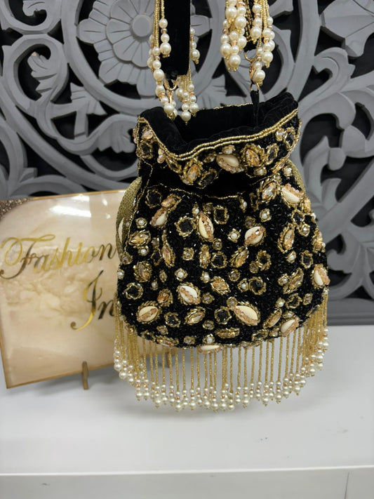 Black and gold beaded handbag with pearls on a decorative background
