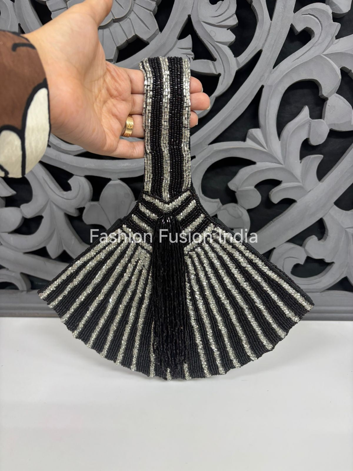 Handcrafted black and silver embroidered potli bag with tassel detail and fan design.