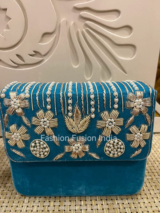 Blue handbag with floral embroidery on a textured surface