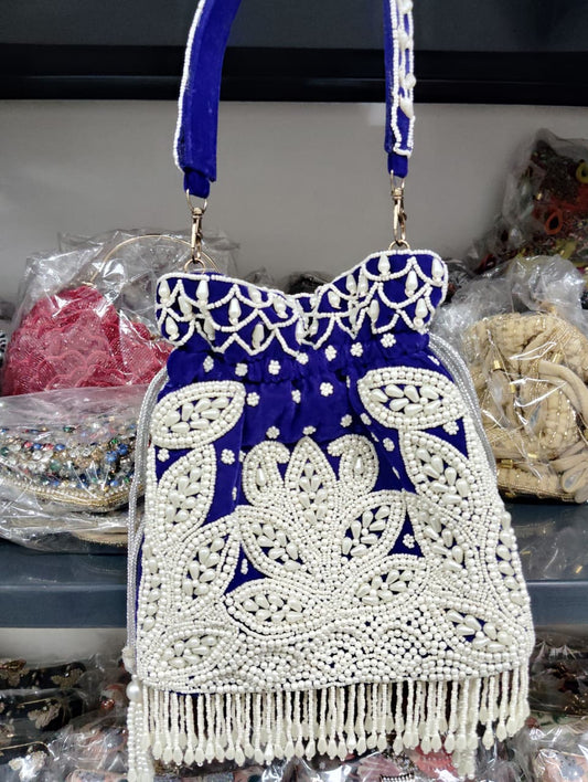 Blue and white beaded handbag with fringe on a blurred background