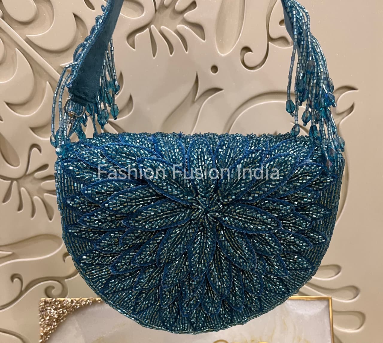 Blue beaded handbag on a decorative background with 'Fashion Fusion India' branding.