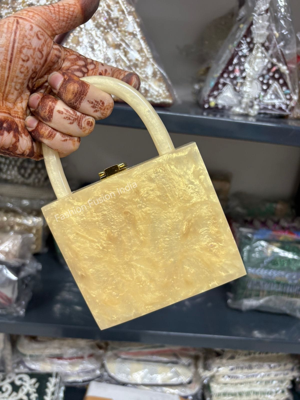 Gold padlock held by a hand with henna designs against a blurred background