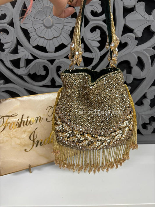 Gold beaded handbag with tassels on a decorative background