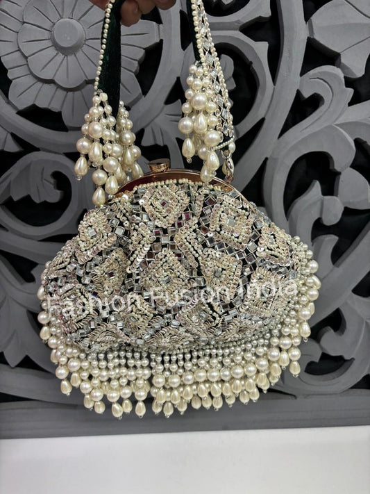 Decorative handbag with pearls and intricate design against a decorative background