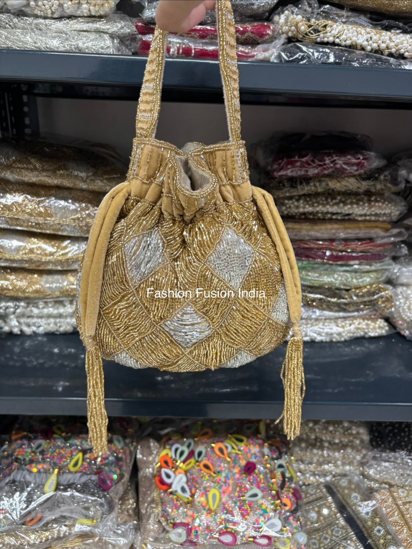 Gold beaded handbag with 'Fashion Fusion India' branding on a blurred background of similar products.