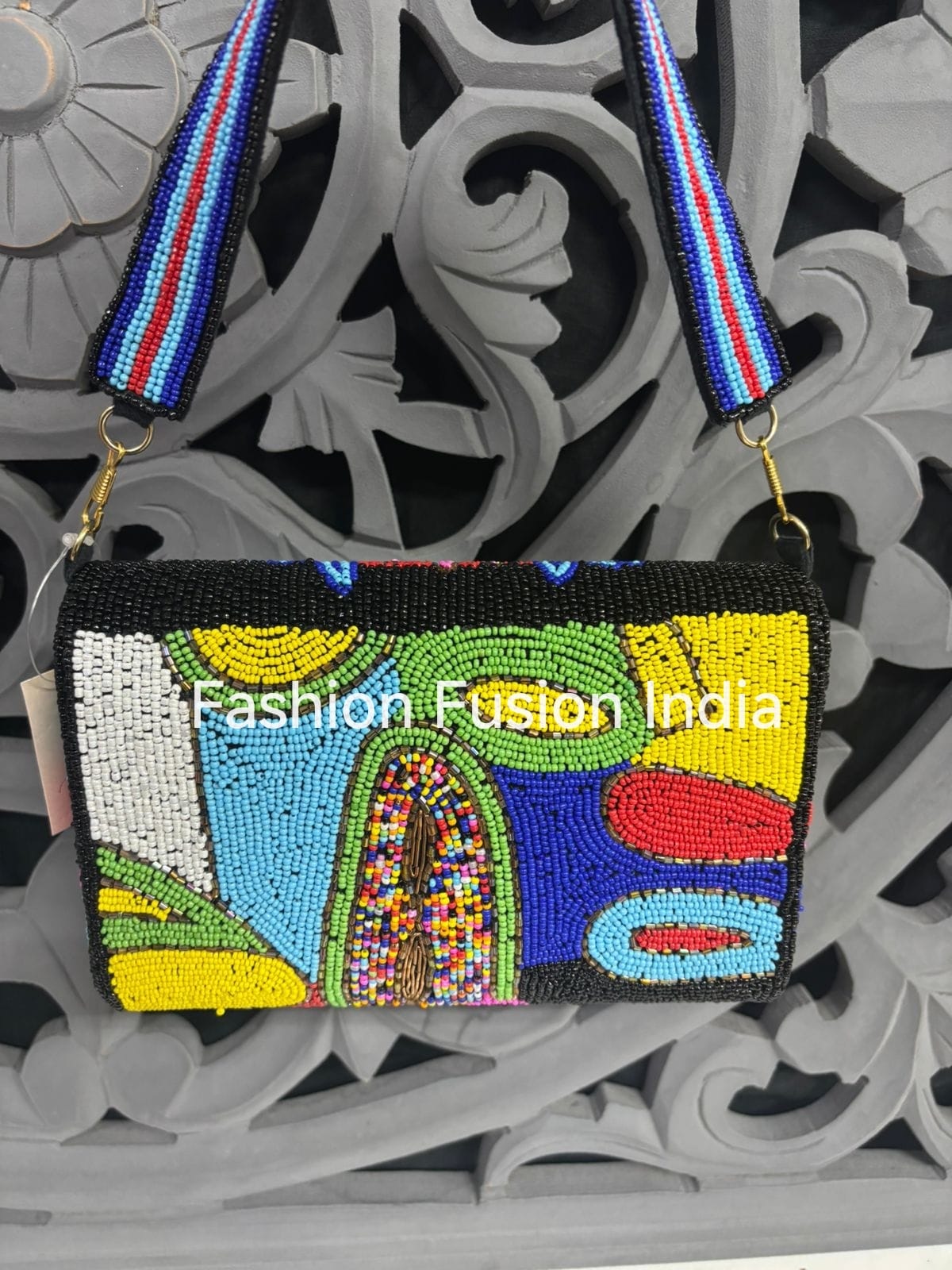 Colorful beaded clutch bag with abstract design on a decorative background, featuring 'Fashion Fusion India' branding.
