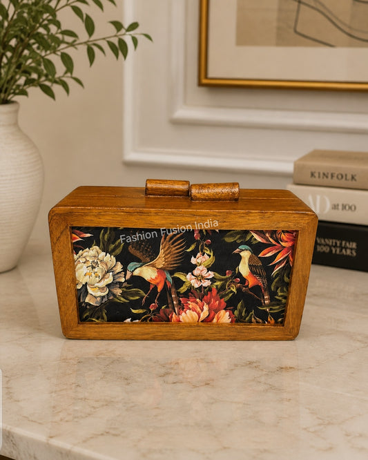 Wooden box clutch with floral and bird artwork on elegant indoor background.